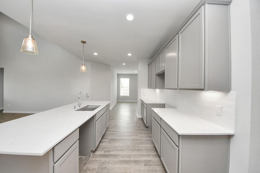 Step into the dream kitchen you've always wanted! This generously spacious culinary haven features a massive granite island, high ceilings, soft-close cabinets, granite countertops, stainless steel appliances, a sleek tile backsplash, and recessed lighting. Sample photo of completed home with similar floor plan. Actual colors and selections may vary. Step into the dream kitchen you've always wanted! This generously spacious culinary haven features a massive granite island, high ceilings, soft-close cabinets, granite countertops, stainless steel appliances, a sleek tile backsplash, and recessed lighting. Sample photo of completed home with similar floor plan. Actual colors and selections may vary.