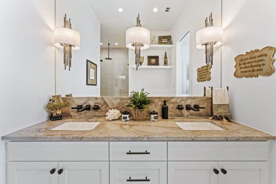 Full bathroom featuring a shower stall, double vanity, and recessed lighting
