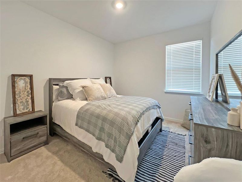 Bedroom featuring light colored carpet and baseboards