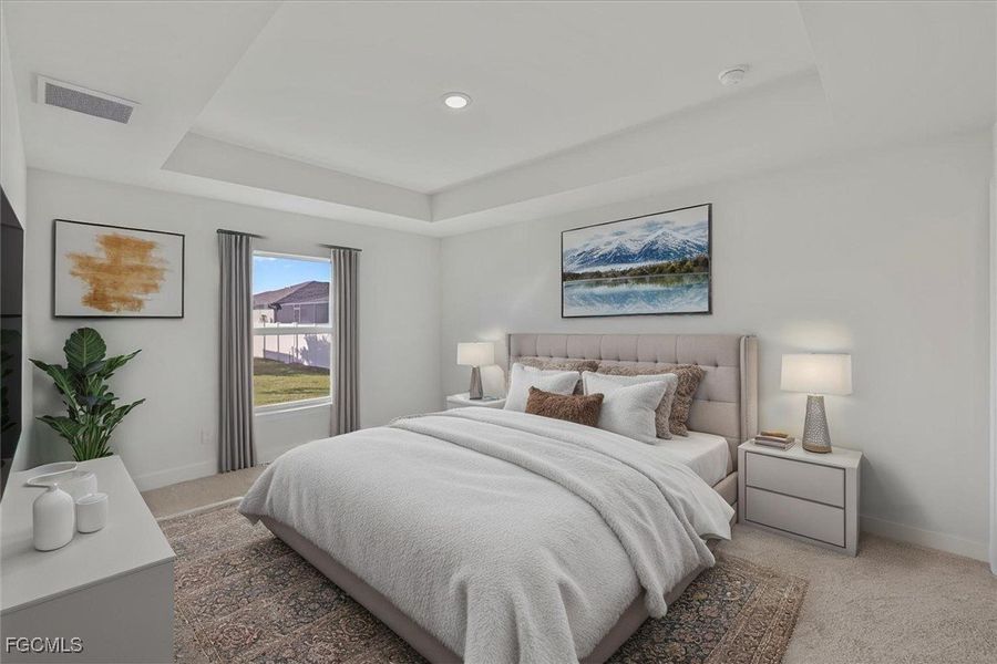 Bedroom with a raised ceiling and carpet floors