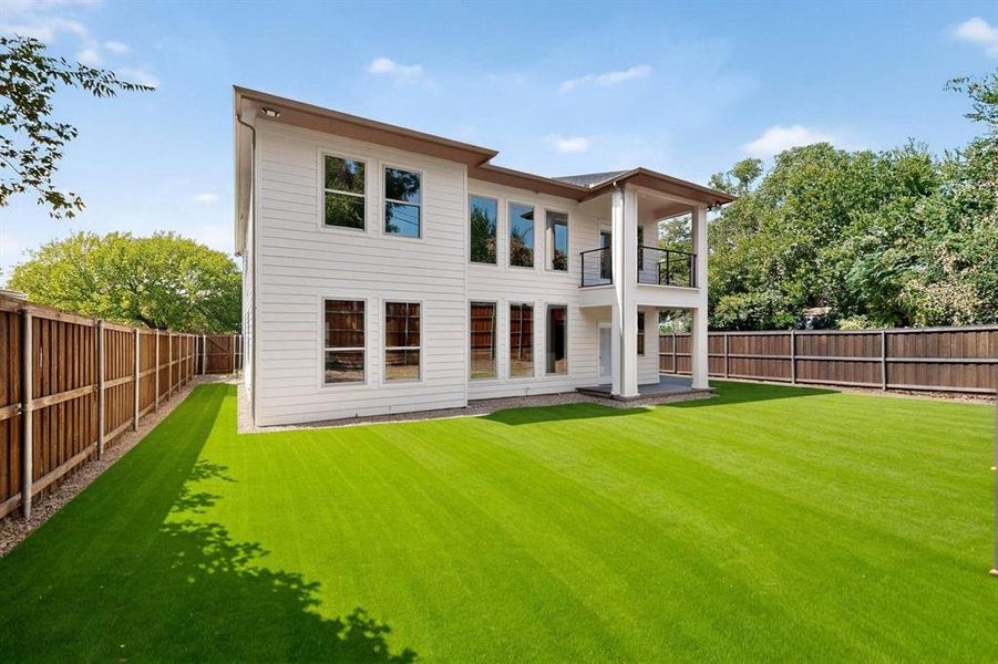Back of house with a balcony, a fenced backyard, and a patio Back of house with a balcony, a fenced backyard, and a patio