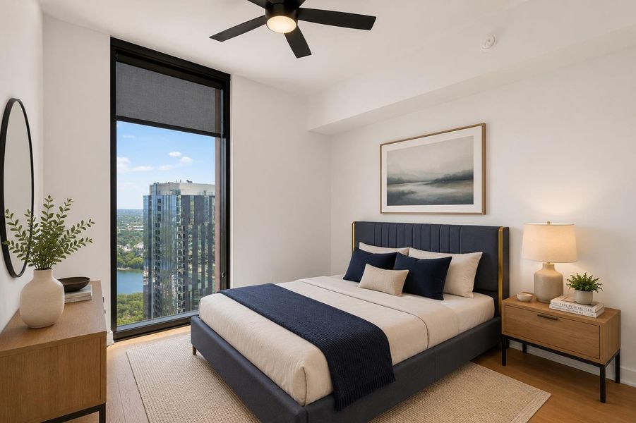 Floor-to-ceiling windows frame a commanding cityscape and lake vista in this tranquil bedroom.
