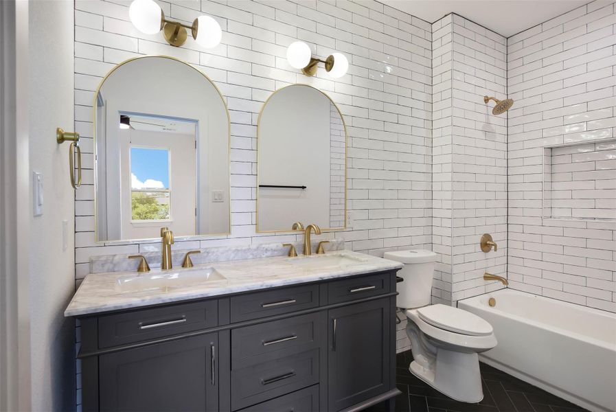 Dual vanities and tiled wall. Tub/shower combo.