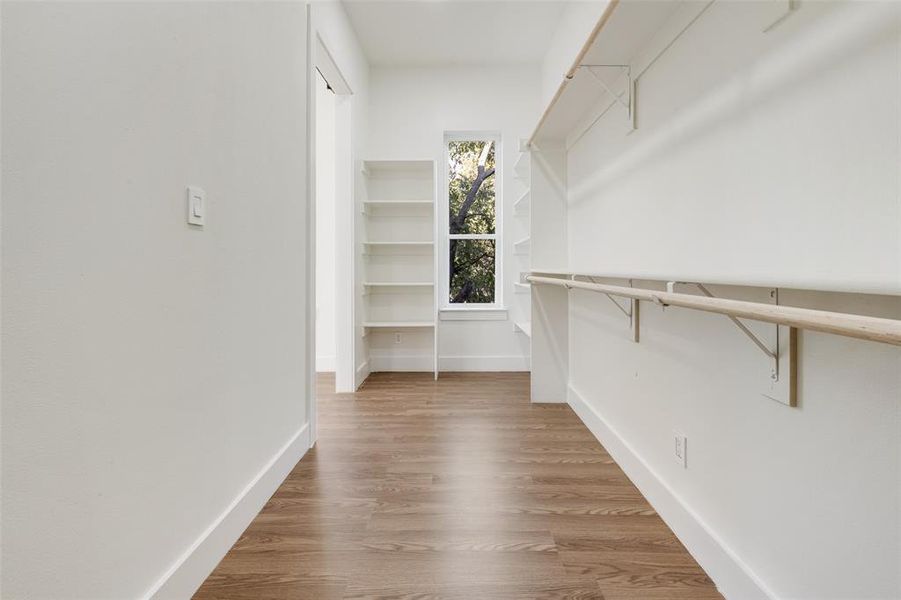 Spacious closet featuring light wood-type flooring Spacious closet featuring light wood-type flooring