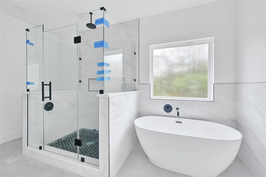 full bath featuring a soaking tub and modern tile surround. full bath featuring a soaking tub and modern tile surround.