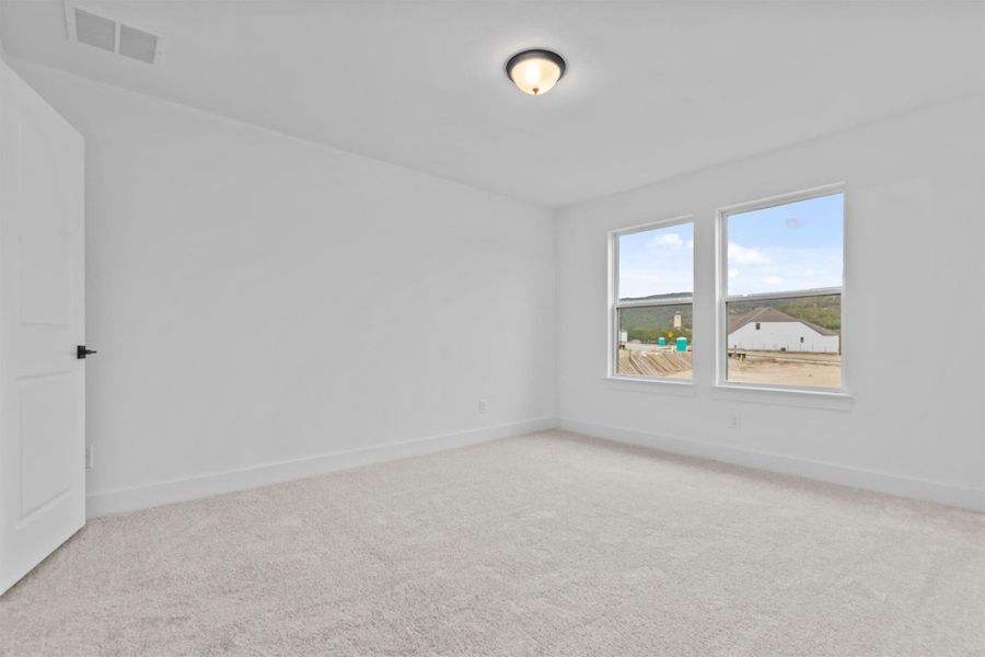 Empty room featuring light colored carpet