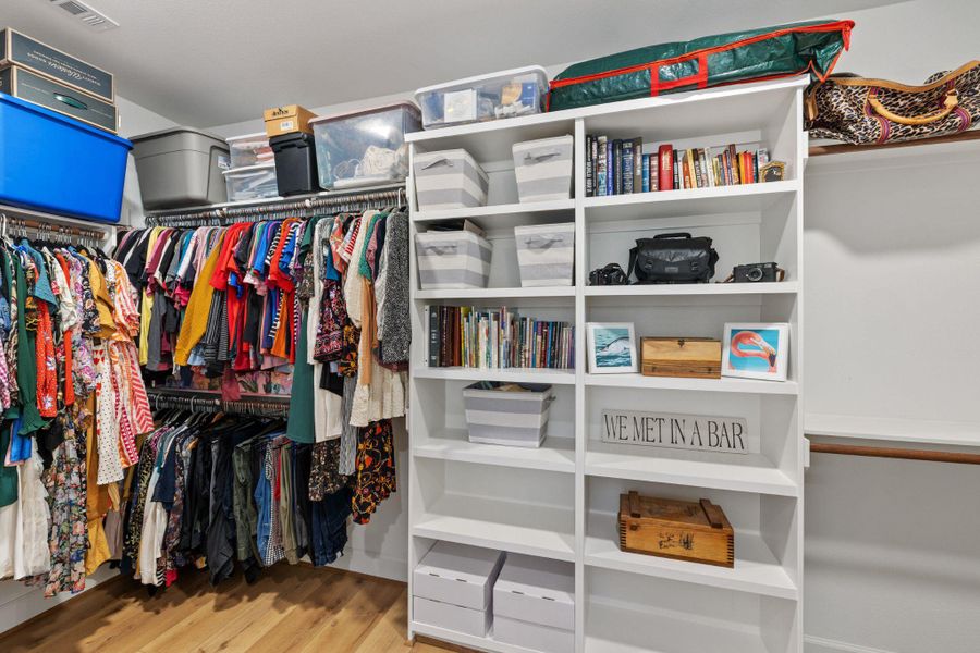 Walk in closet with light wood-style floors