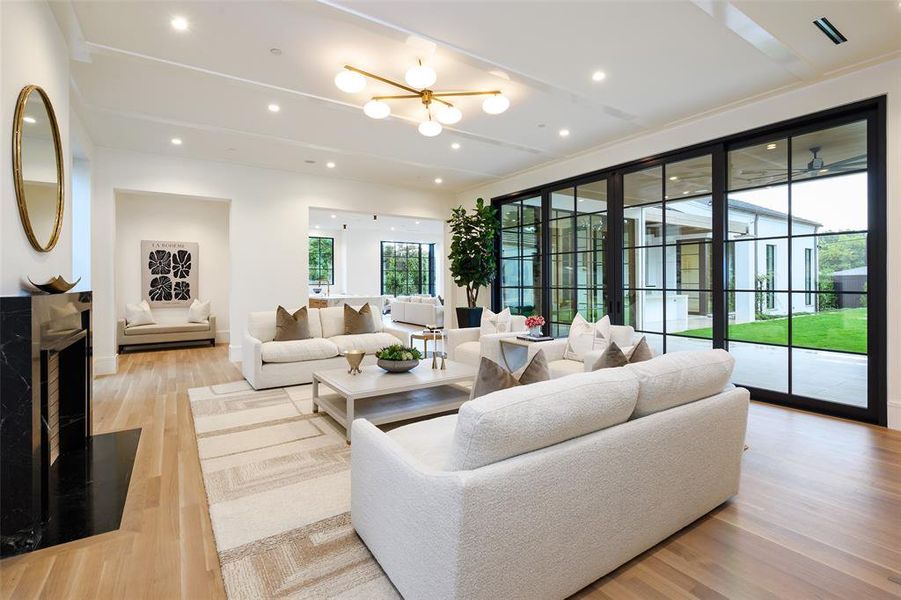 Living area featuring recessed lighting, a chandelier, light wood finished floors, and a fireplace Living area featuring recessed lighting, a chandelier, light wood finished floors, and a fireplace