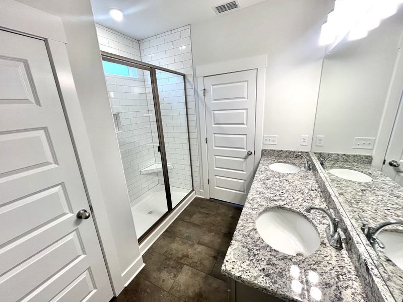 Double raised vanity, granite counters, tile shower and linen closet