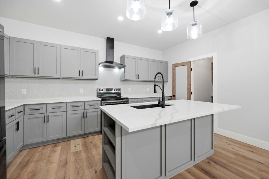 A well-appointed kitchen showcasing contemporary gray cabinetry and luminous white countertops. A well-appointed kitchen showcasing contemporary gray cabinetry and luminous white countertops.