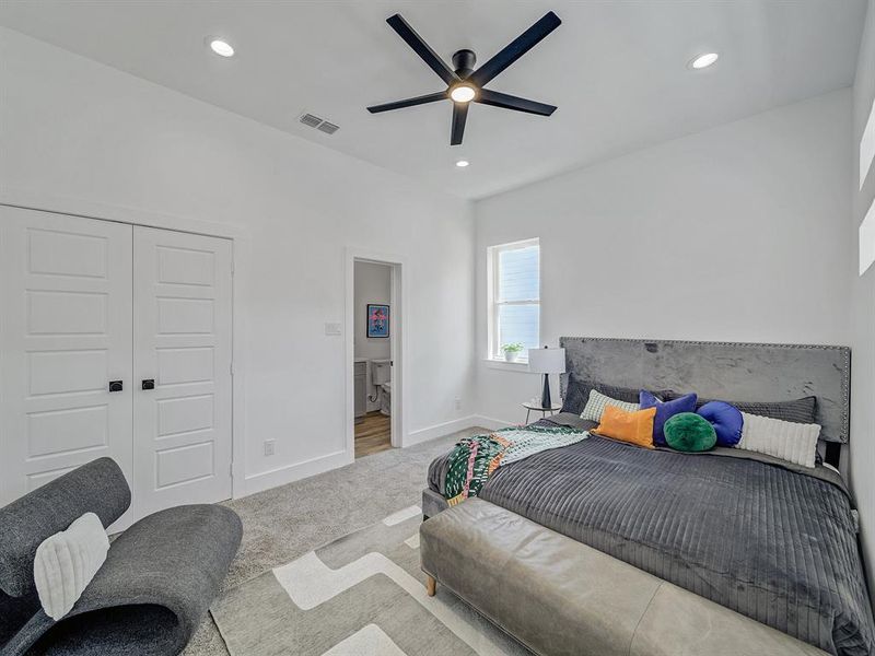 Bedroom with light colored carpet, a closet, and ceiling fan