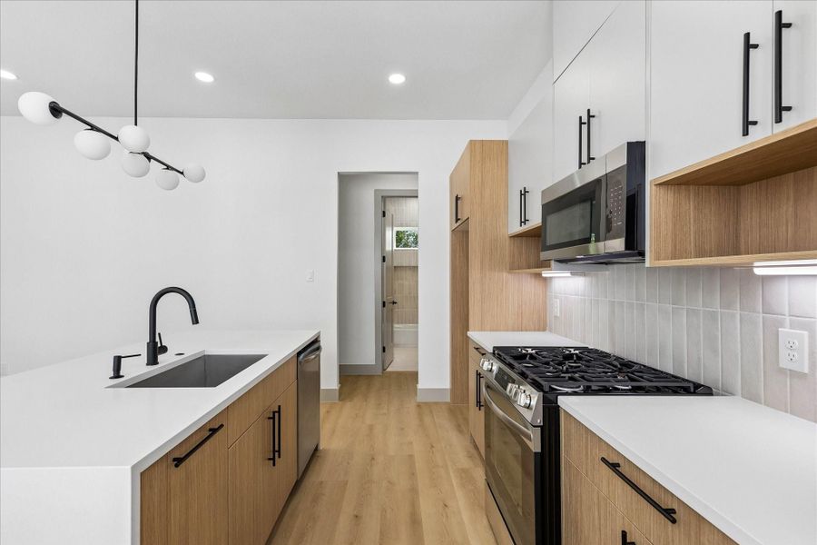 An oversized waterfall island offers generous prep space, bar seating, and an effortless connection between the kitchen, dining area, and living spaces.