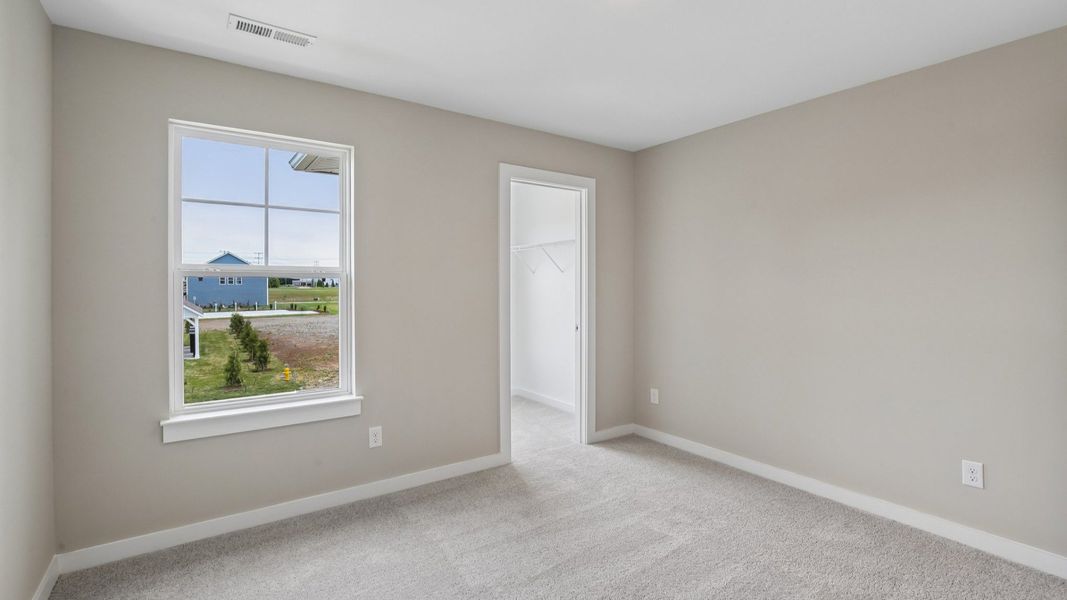 Bedroom with walk-in closet and window Bedroom with walk-in closet and window