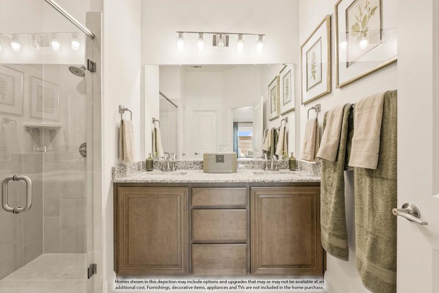 Bathroom with double vanity, granite countertops, wood cabinets, large mirror, and glass shower enclosure