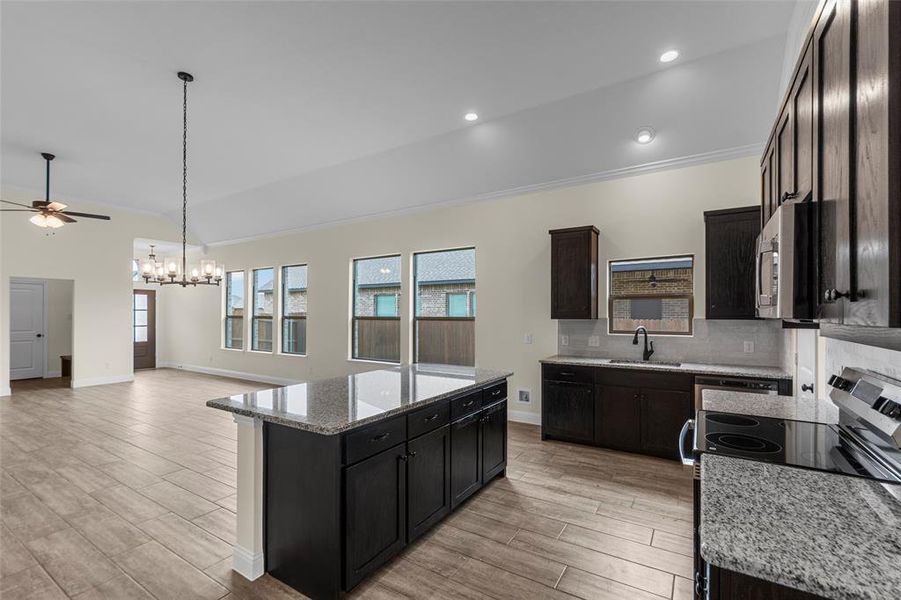 Spacious kitchen featuring dark cabinetry, granite countertops, and stainless steel appliances