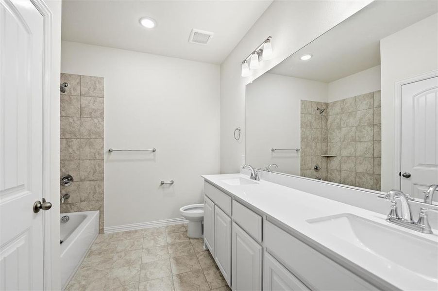 Full bathroom featuring double vanity, bathing tub / shower combination, and recessed lighting