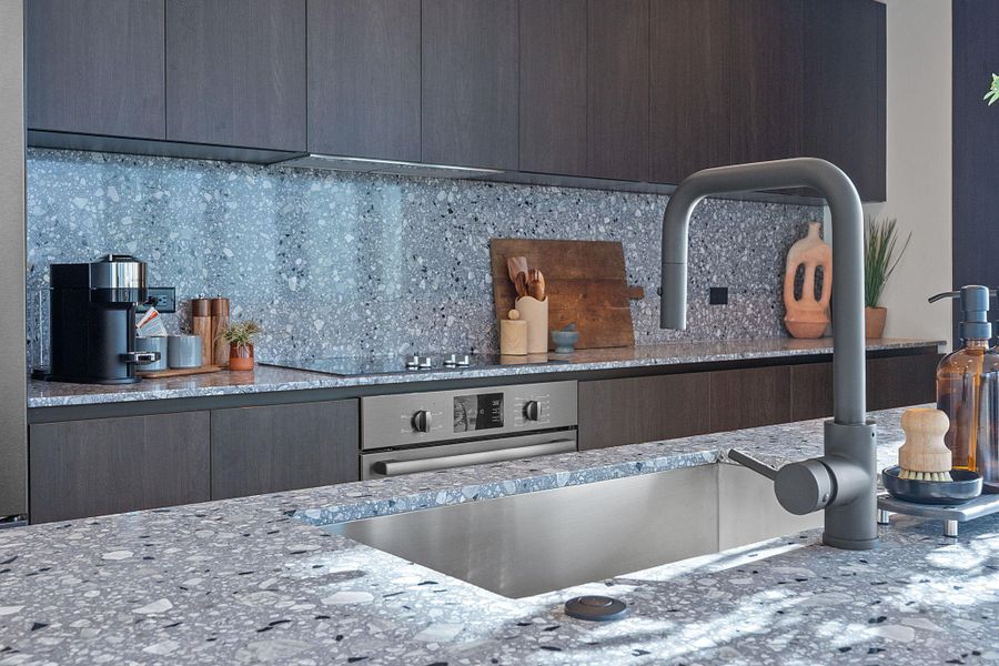 The island functions as a dining space and draws your eye to the beautiful terrazzo-quartz backsplash.
