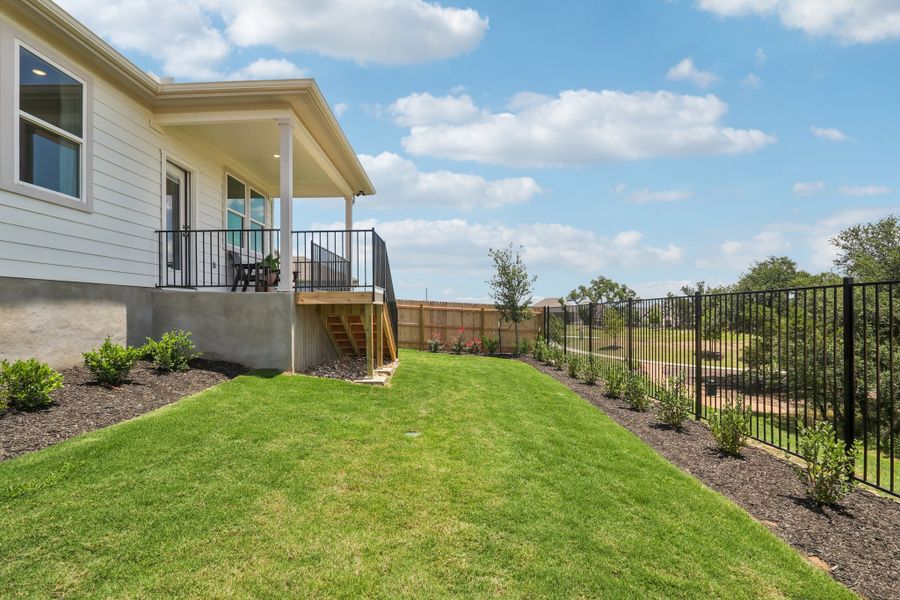 A house with a fence and a lawn in front of it. A house with a fence and a lawn in front of it.