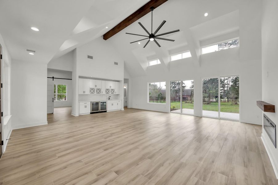 Open-concept living room designed for both entertaining and everyday comfort, featuring high ceilings, large windows, and seamless flow to the outdoor living space.