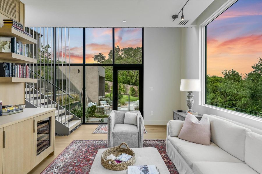 Living room featuring light wood-type flooring, plenty of natural light, track lighting, and stairway