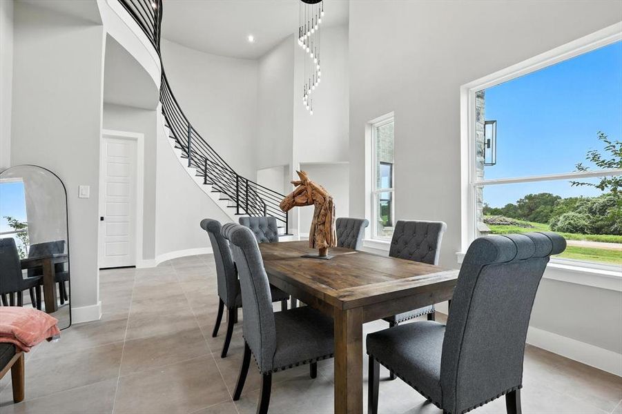 Dining space with a towering ceiling and stairway