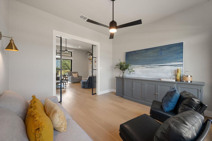 Rich hardwood floors and elegant built-in cabinetry define this versatile living area.