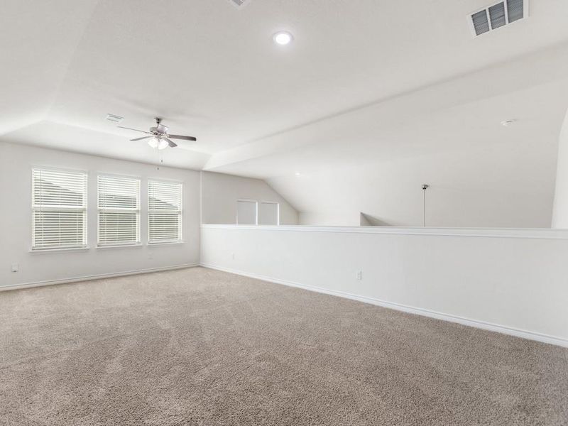 Spare room featuring vaulted ceiling, a ceiling fan, carpet flooring, and recessed lighting