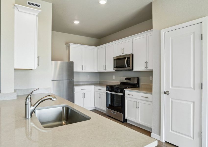 The kitchen has stainless steel appliances and white cabinets.
