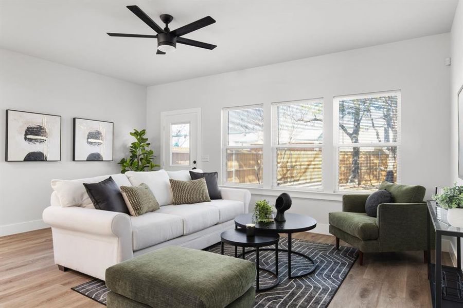 Living room with light wood-type flooring, baseboards, and a ceiling fan