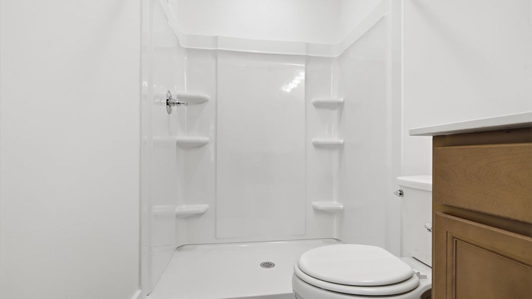 Accomplished design shines in this primary bath with dual vanity and a sleek walk-in shower