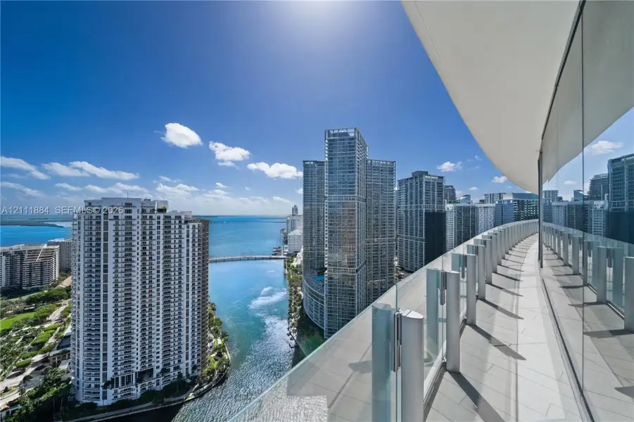 Wraparound balcony featuring large-format tile flooring and a glass panel railing Wraparound balcony featuring large-format tile flooring and a glass panel railing