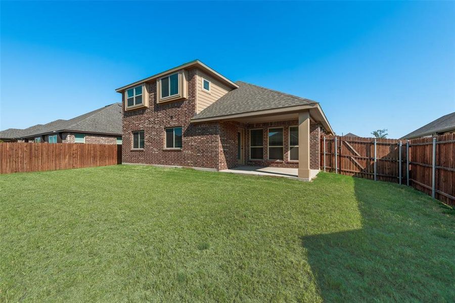 Rear view of house featuring a patio, a fenced backyard, a shingled roof, and brick siding Rear view of house featuring a patio, a fenced backyard, a shingled roof, and brick siding
