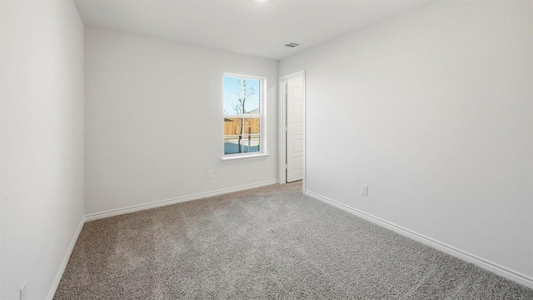 Room featuring light gray carpet, white walls, and a window providing natural light