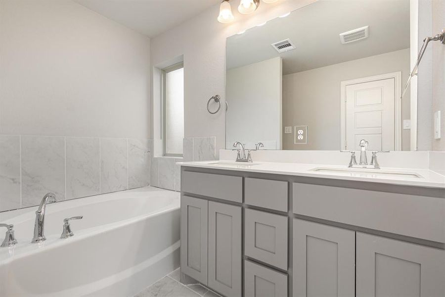 Bathroom featuring a washtub and vanity