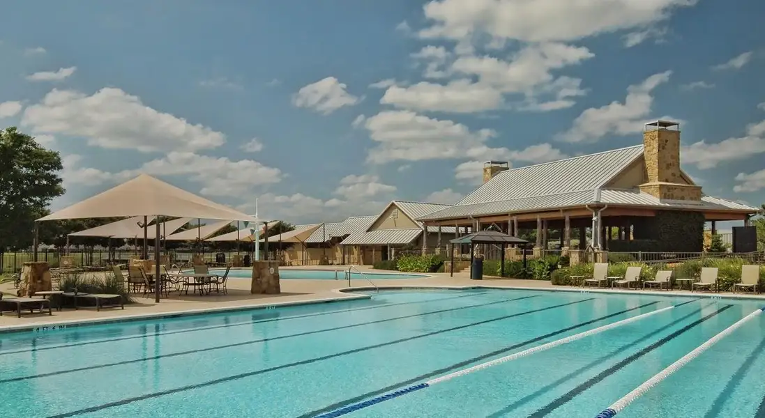 Laps in a sparkling pool with a clubhouse and shaded outdoor dining areas create a perfect recreational oasis.