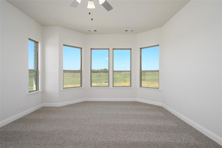 Carpeted empty room with ceiling fan