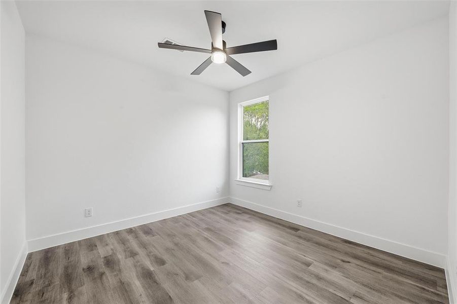 Unfurnished room with wood finished floors and ceiling fan