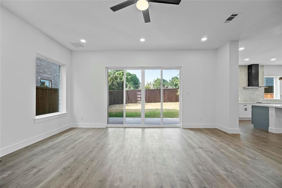 Unfurnished living room featuring a ceiling fan, wood finished floors, and recessed lighting Unfurnished living room featuring a ceiling fan, wood finished floors, and recessed lighting