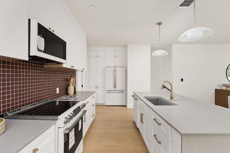 Culinary delights await in this bright kitchen with a spacious island and modern appliances. Culinary delights await in this bright kitchen with a spacious island and modern appliances.