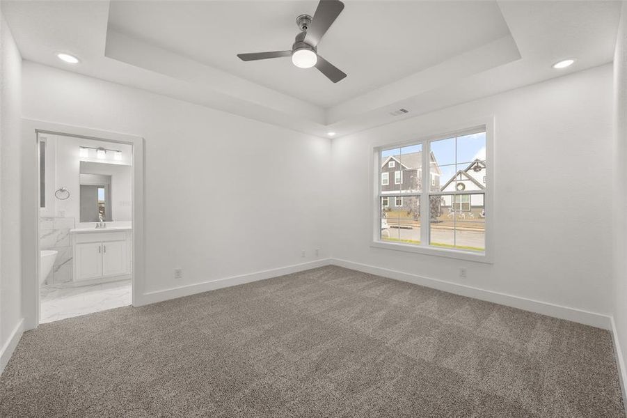 Primary bedroom with carpet and ensuite bathroom