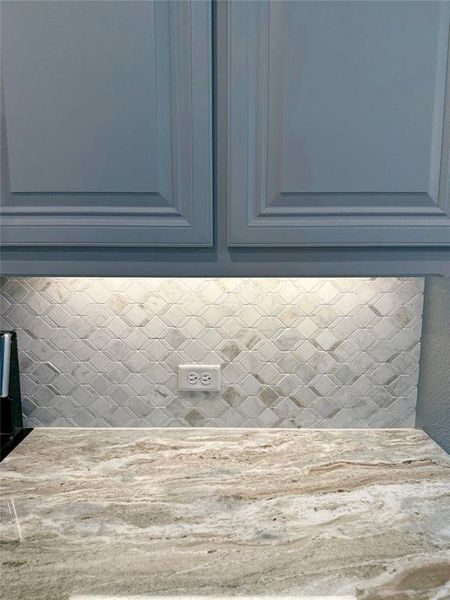 Fantasy Brown granite, mosaic backsplash, and white custom, raised-panel cabinets