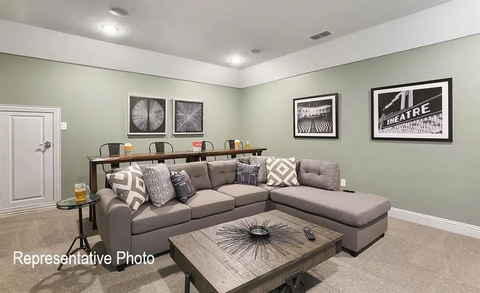 Spacious entertainment room featuring recessed lighting, light green walls, and carpet flooring
