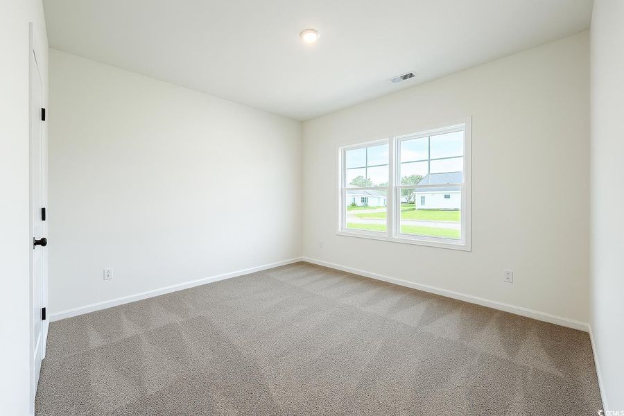 Empty room with carpet floors and baseboards Empty room with carpet floors and baseboards