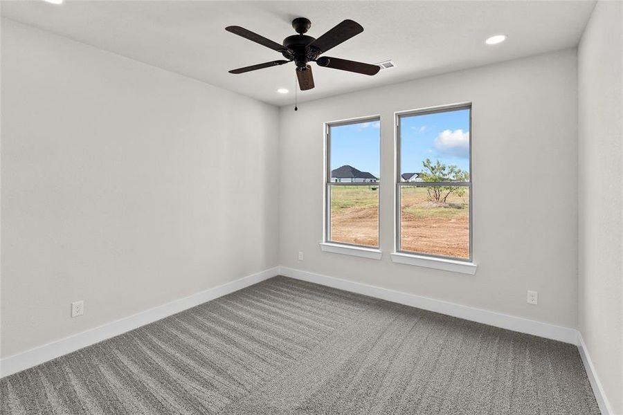 Empty room featuring carpet flooring and ceiling fan