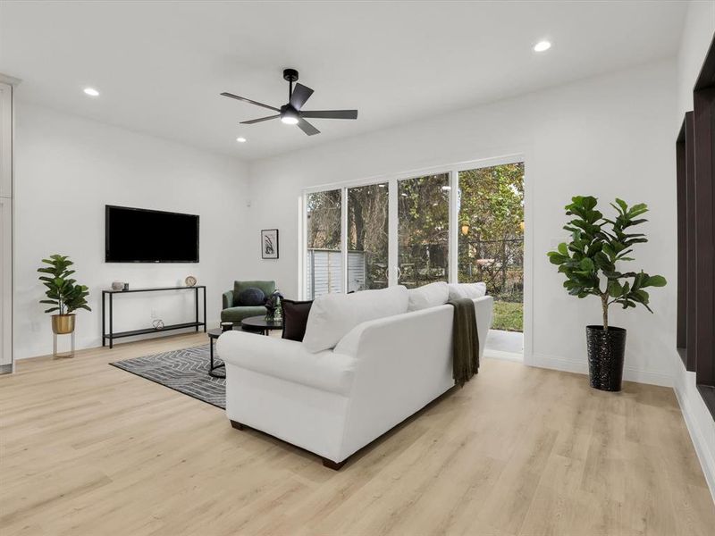 Living room with light hardwood / wood-style floors and ceiling fan