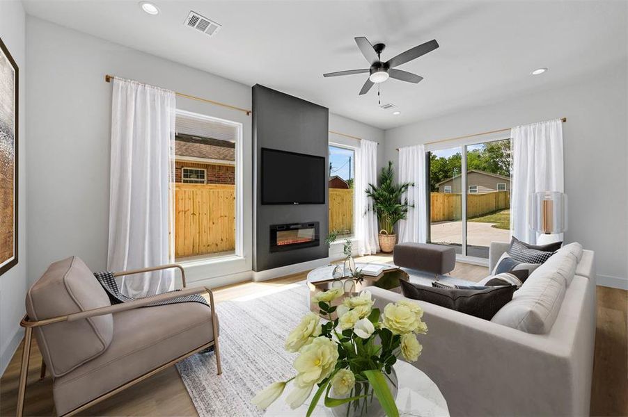 Virtually Staged Living room featuring light wood-type flooring, a large fireplace, and ceiling fan