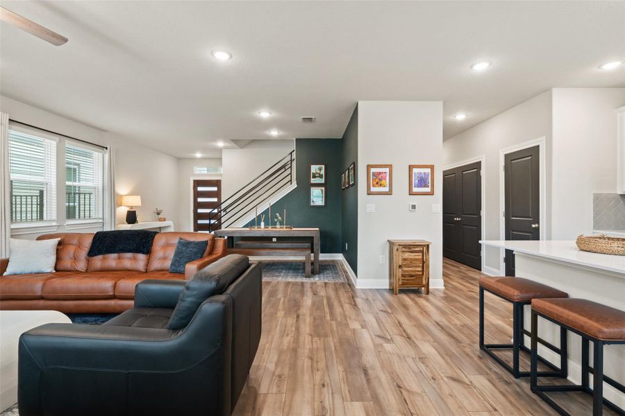 Living area with baseboards, recessed lighting, light wood-style flooring, stairs, and visible vents