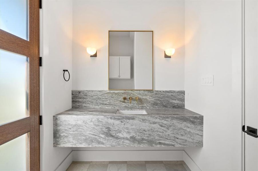 Powder bath with leather finish marble vanity. Previous TOMO Homes project.