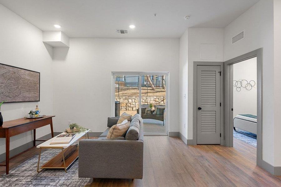 Sitting room featuring wood finished floors, a high ceiling, and recessed lighting