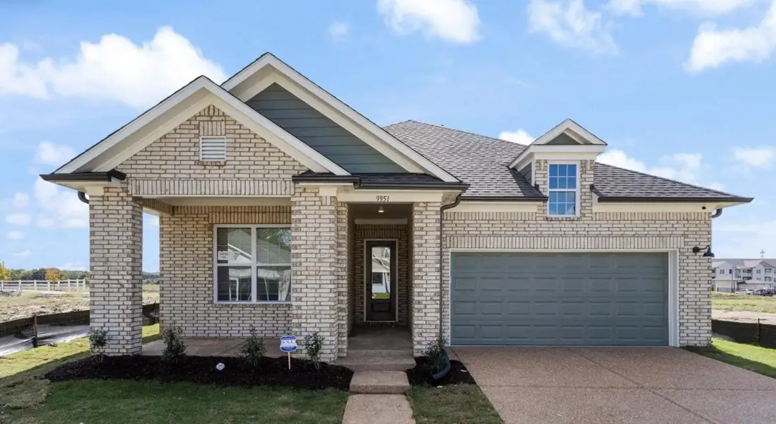 Light-toned brick exterior with dark trim accents, covered entry, attached two-car garage, and a gabled roofline Light-toned brick exterior with dark trim accents, covered entry, attached two-car garage, and a gabled roofline